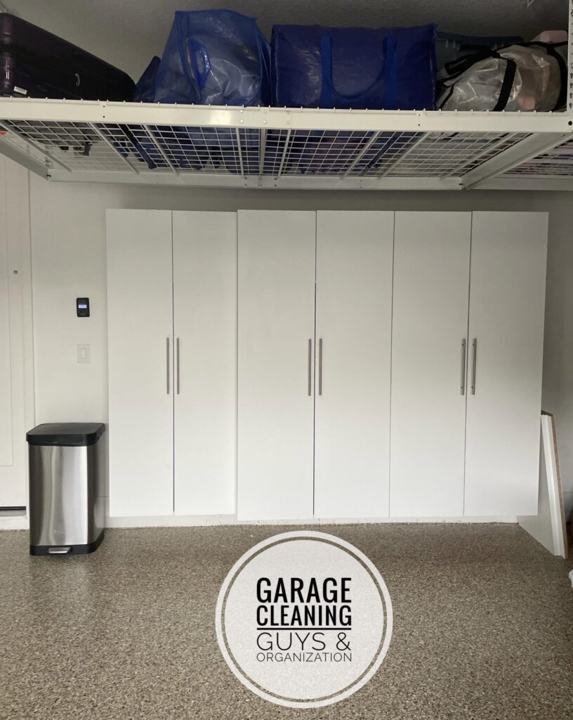 After garage makeover in Delray Beach showing a clean, organized garage with cabinets, shelving, overhead storage racks, and clear floor space.
